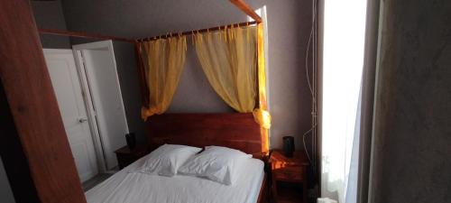 une chambre avec un lit avec une tête de lit en bois et une fenêtre dans l'établissement Villa Mon Repos 3, à La Bourboule