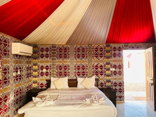 a bedroom with a bed with a red ceiling at Rum Kingdom Camp in Wadi Rum