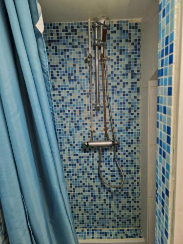 La salle de bains est pourvue d'une douche et de carrelage bleu. dans l'établissement Secret de Richebourg - Cœur du Mans - 4pers, au Mans