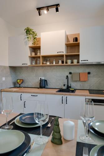 a kitchen with a table with plates and wine glasses at Vila Dara in Vrnjačka Banja