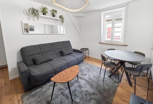un salon avec un canapé et une table dans l'établissement Calme et confort au cœur du vieux Troyes, à Troyes
