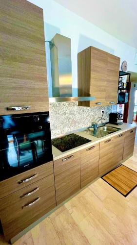 a kitchen with wooden cabinets and a sink at Andrea e Sofia Rho Fiera Milano in Rho
