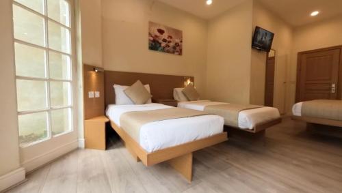 a hotel room with two beds and a window at NOX Olympia in London