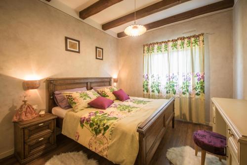un dormitorio con una cama y una ventana en Villa Maslina, a charming and private villa 15 km from the sea, en Pićan