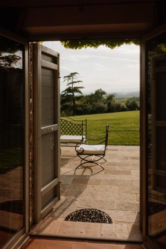 a door to a porch with a bench behind it at Podere la Piscina RestArt in San Casciano dei Bagni