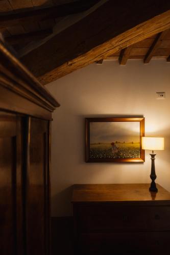 a lamp on a table with a mirror on a wall at Podere la Piscina RestArt in San Casciano dei Bagni