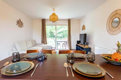une salle à manger avec une table, des assiettes et des verres dans l'établissement L'appart des pins, à Tosse