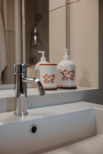 a bathroom sink with two cups on a mirror at Podere la Piscina RestArt in San Casciano dei Bagni