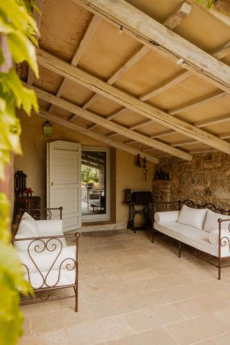 a patio with two white couches and a piano at Podere la Piscina RestArt in San Casciano dei Bagni