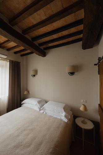 a bedroom with a large bed with white pillows at Podere la Piscina RestArt in San Casciano dei Bagni