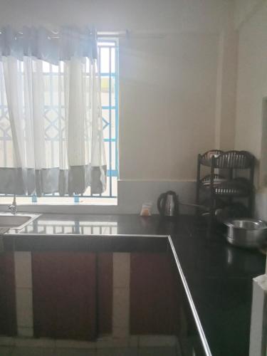 a kitchen with a counter top and a window at Miles haven in Kakamega