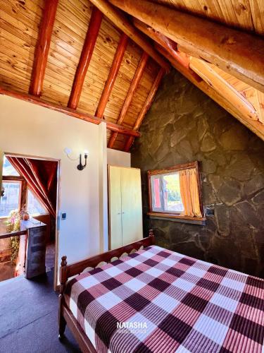 a bedroom with a bed in a house at Natasha Hostel Boutique in Caviahue