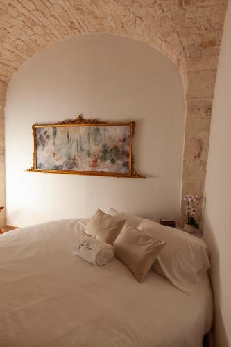 a bedroom with a white bed with a painting on the wall at Je T'Aime Via G Valentino in Conversano