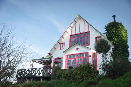 a large white house with red windows at Casa Museo Residencia in Castro