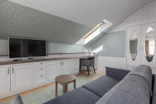 a living room with a couch and a tv at Roze Boutique Hotel in Liepāja