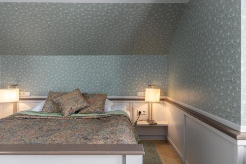 a bedroom with a bed and two lamps on the wall at Roze Boutique Hotel in Liepāja