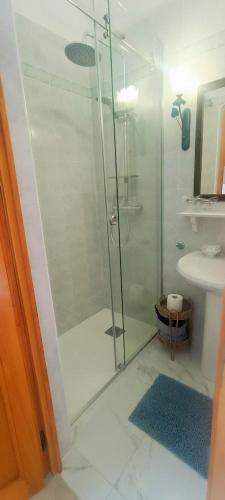 a bathroom with a glass shower with a sink at Apartments Sara in Bale
