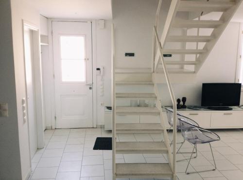 レフカダにあるDesigner apartmentのテレビとドアが備わる客室内の階段