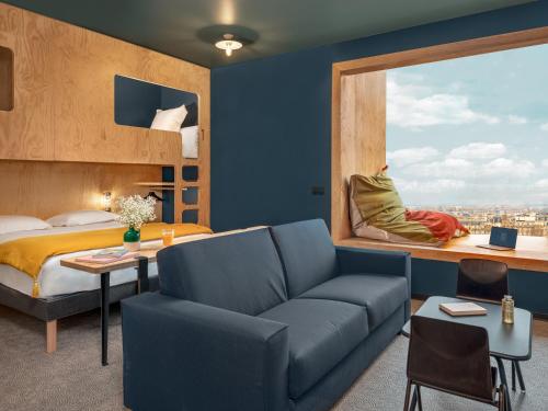 - une chambre avec un canapé, un lit et une fenêtre dans l'établissement Eklo Nantes Centre Ile de Nantes, à Nantes