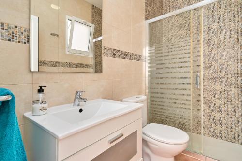 a bathroom with a sink and a toilet and a mirror at Animas in Nerja