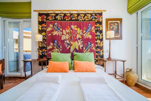 a bedroom with a large bed with orange and green pillows at Sunbay Casablanca Apartment Javea Arenal by Rock Rentals in Platja de l'Arenal