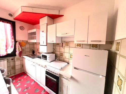 a kitchen with white cabinets and a white refrigerator at Al glicine in Lovere