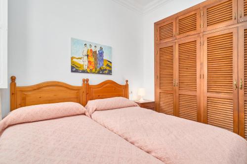 a bedroom with a bed with a wooden headboard at Animas in Nerja