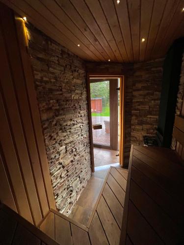 an empty room with a stone wall and a door at Roheluse metsamaja with hot tub and sauna in Kõrve Üks