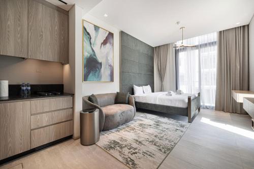 Una habitación de hotel con una cama, un sofá y una mesa. en Studio with Balcony and Coworking Space in The Autograph JVC, en Dubái