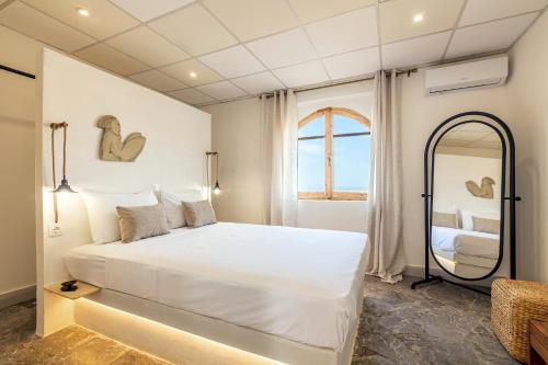 a bedroom with a large white bed and a mirror at Villa Zoi in Sissi