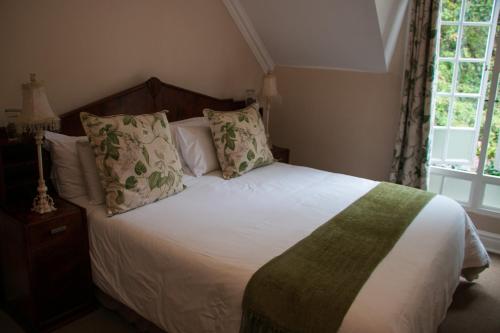 a bedroom with a bed with white sheets and pillows at Rawdons Hotel & Brewery in Nottingham Road