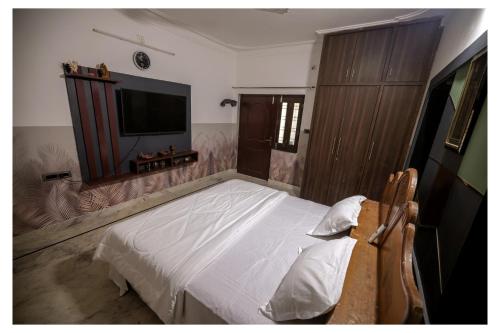 a bedroom with a bed and a flat screen tv at Brijwasi Bhawan in Udaipur