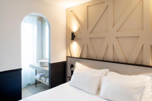 a bedroom with a bed with a large wooden headboard at Logis Hotel Darcy Dijon Centre in Dijon