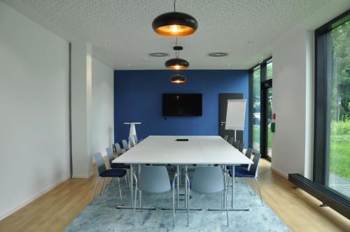 a dining room with a white table and chairs at Holiday Inn - the niu Star Sindelfingen by IHG in Sindelfingen