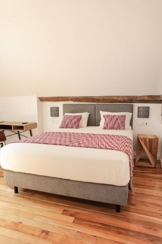 a bedroom with a large bed with two pillows at Quinta dos Tojais Hotel Rural in Celorico de Basto