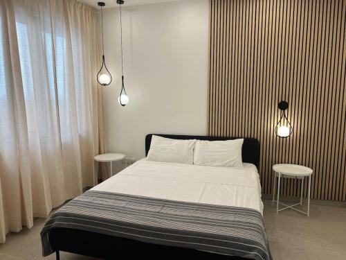 スリーマにあるCharming Sliema Sea Escapeのベッドルーム1室(ベッド1台、テーブル2台、照明2つ付)