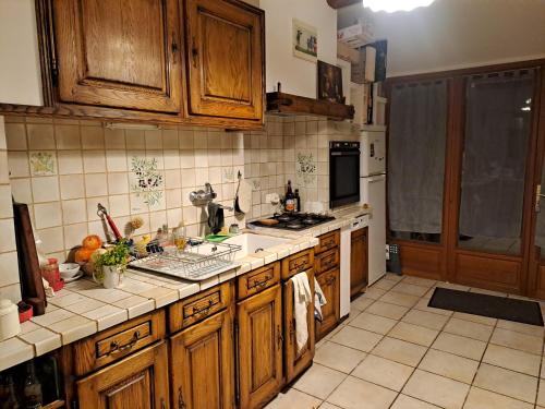 une cuisine avec des armoires en bois et un comptoir dans l'établissement Villa au bord du Tarn avec barnum événement, à Montbrun