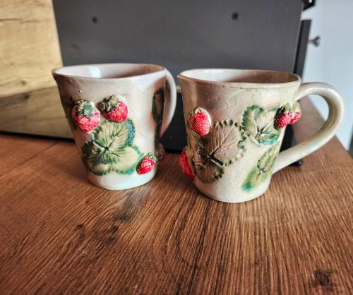 two coffee mugs sitting on top of a wooden table at Elly Kodumajutus Kihnus in Linaküla