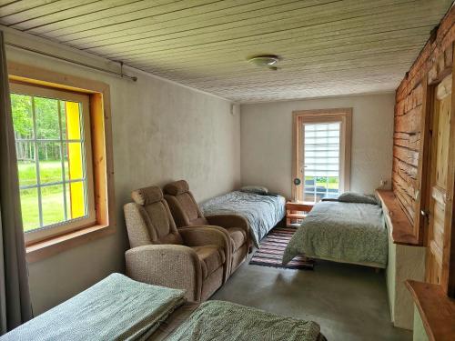 a room with two beds and a couch and a window at Elly Kodumajutus Kihnus in Linaküla