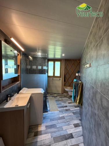 une salle de bain avec un lavabo, une baignoire et des toilettes dans l'établissement NOUVEAU !!!! Yourte contemporaine, à Arzano