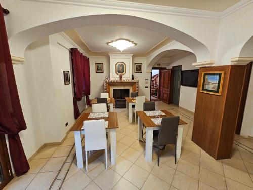 a dining room with tables and chairs and a fireplace at Villa Nino in Palermo