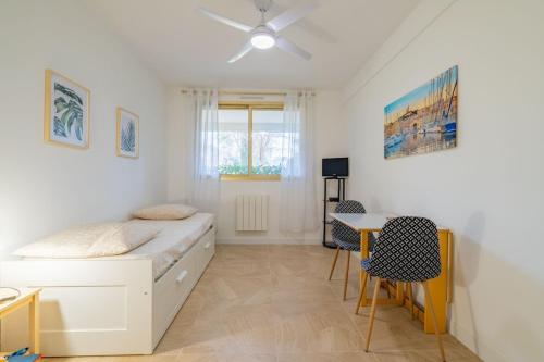 une chambre avec un lit, une table et des chaises dans l'établissement Les Roches d'Or, nice studio, à Marseille
