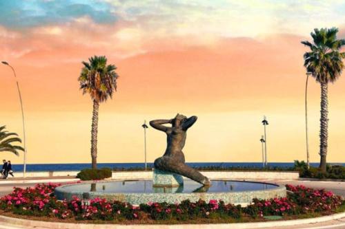 a statue of a woman sitting in a fountain near the beach at Villa Yucca - B&B and Glamping in Torano Nuovo