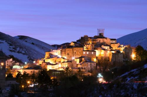 a town on a hill in the snow at night at Villa Yucca - B&B and Glamping in Torano Nuovo
