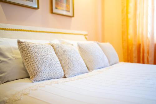 Una cama blanca con cuatro almohadas. en CASA DEL GELSO, en Montefiore dellʼAso
