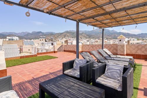 a balcony with chairs and a view of a city at Animas Duplex in Nerja