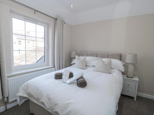 a bedroom with a white bed with a window at Royal Terrace Sunset in Weymouth