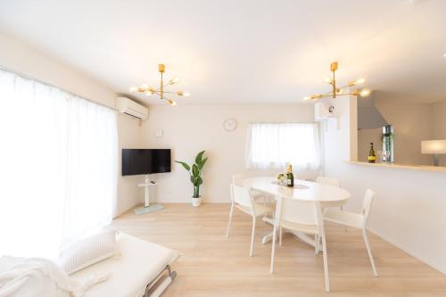 a dining room with a white table and chairs at Miraie Suzuka Shimomida in Suzuka