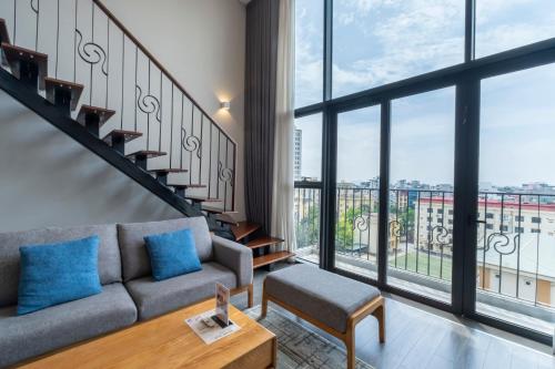 a living room with a couch and a large window at Luxury Pentstudio Westlake - Tay Ho, Ha Noi in Hanoi