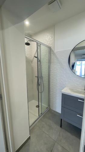 a bathroom with a glass shower and a sink at Résidence San Paolisa in Hyères